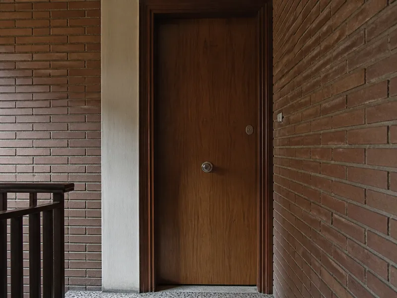 Cerradura de embutir y bombín europeo en una puerta de madera de bloque residencial, sin personas
